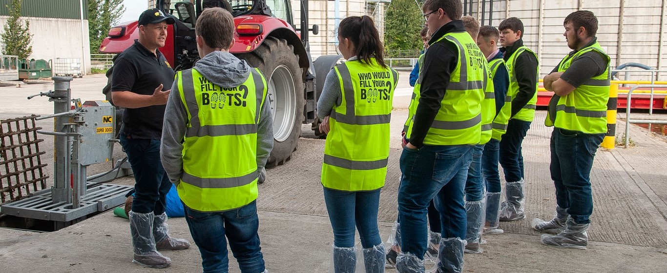 School children receiving a talk about farm safety in front of farm machinery